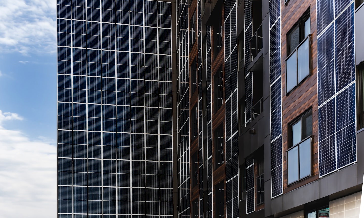 Façade de bâtiment moderne avec panneaux solaires bleus et accents de bois.